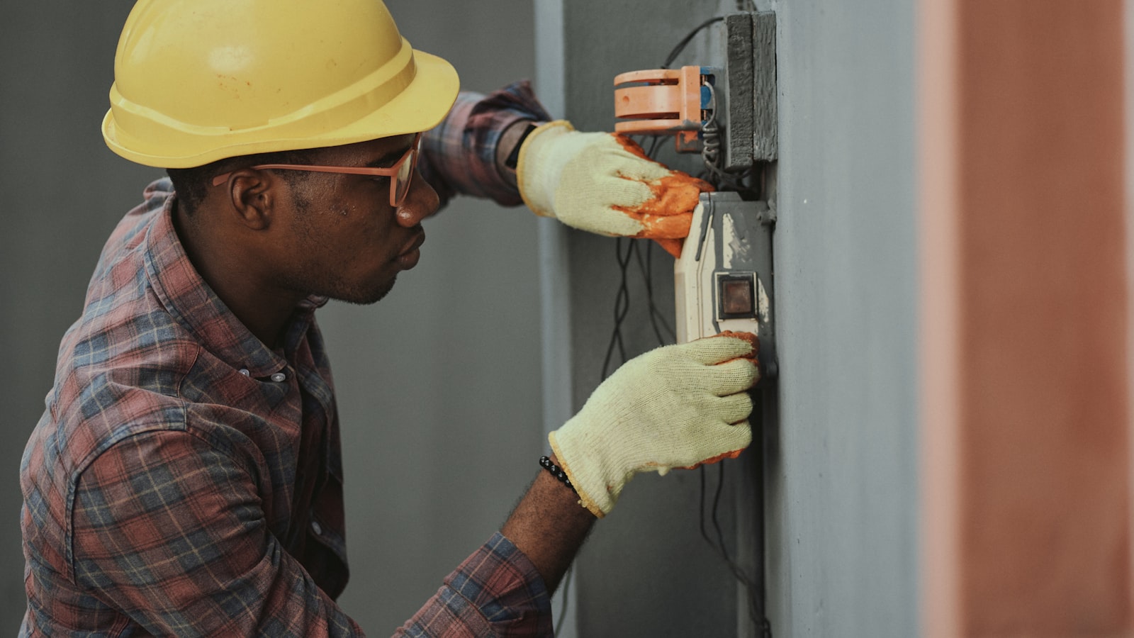 Hands installing a smart thermostat